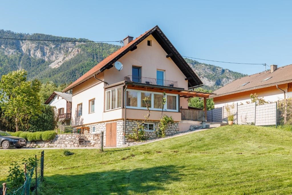 A beautiful house with a large garden and a view of the mountains. The surroundings are green and inviting.