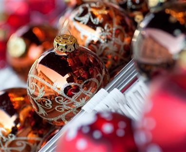 A beautiful sight of shiny Christmas baubles in various colors. The golden and red ornaments radiate a festive spirit.