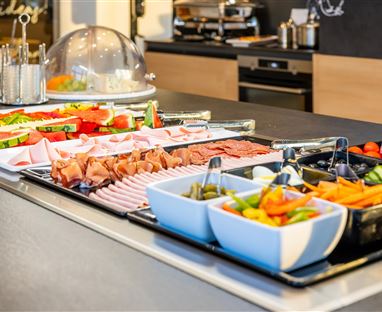 Ein reichhaltiges Frühstücksbuffet mit frischem Obst, Gemüse und Aufschnitt. Die Auswahl ist vielfältig und ansprechend präsentiert.