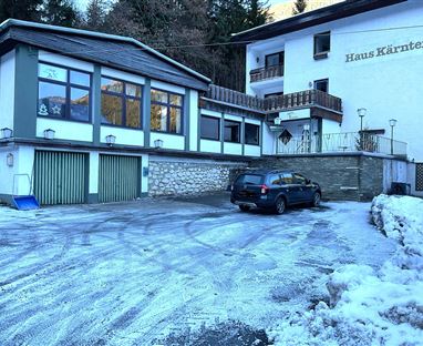 Ein Gebäude namens „Haus Kärnten“ in einer schneebedeckten Umgebung.