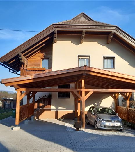 Ein modernes Haus mit einem überdachten Parkplatz. Die Architektur ist ansprechend und umgeben von einer schönen Landschaft.