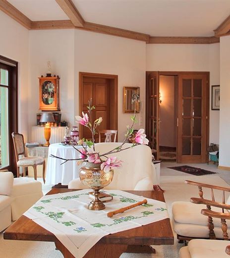 Un luminoso soggiorno con mobili comodi e un tavolo decorativo.
Composizioni floreali e dettagli artistici conferiscono all'ambiente un'atmosfera accogliente.